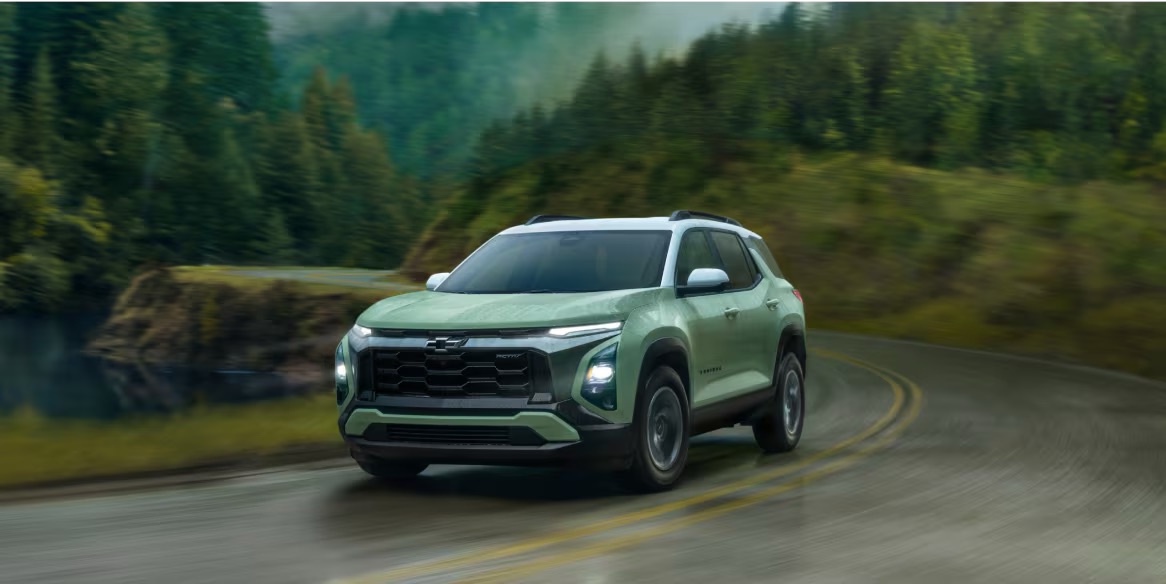 A green 2025 Chevy Equinox driving in nature in Rockford, IL